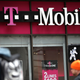 edestrians walk by a T-Mobile store.